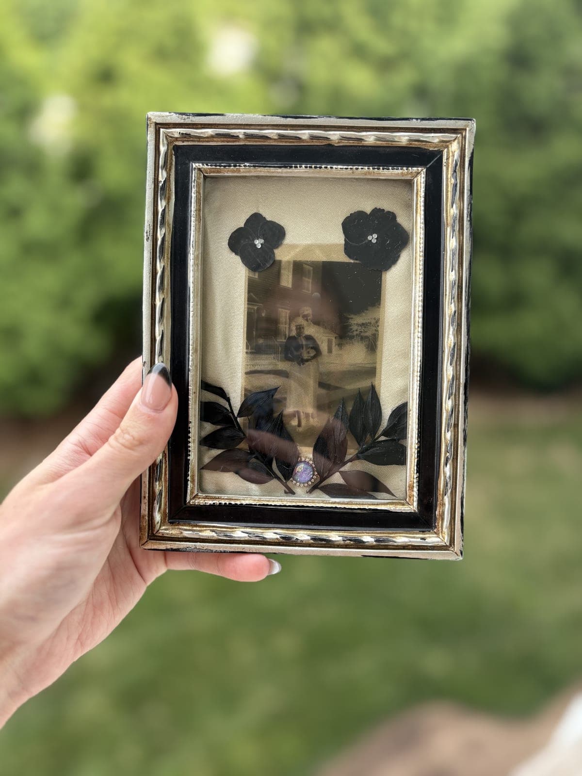 Ornate black and silver frame, dark florals