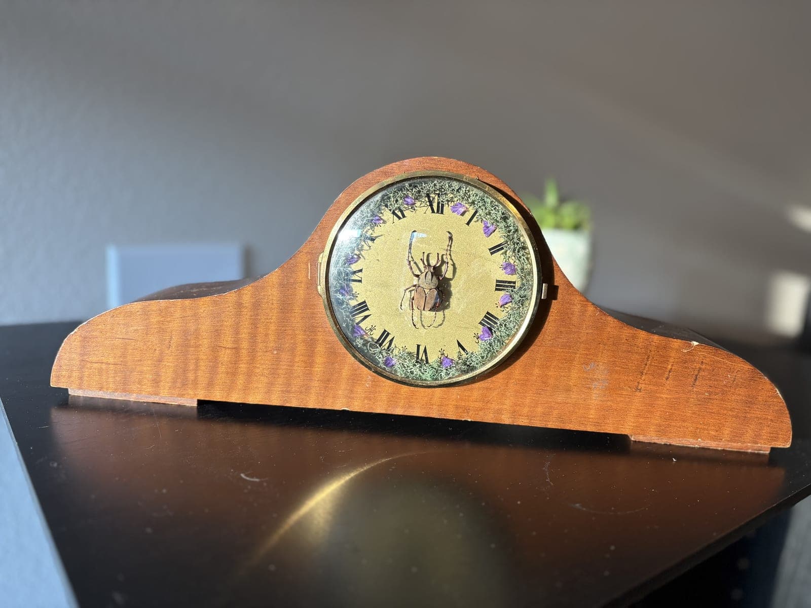 Wooden mantel clock with beetle face